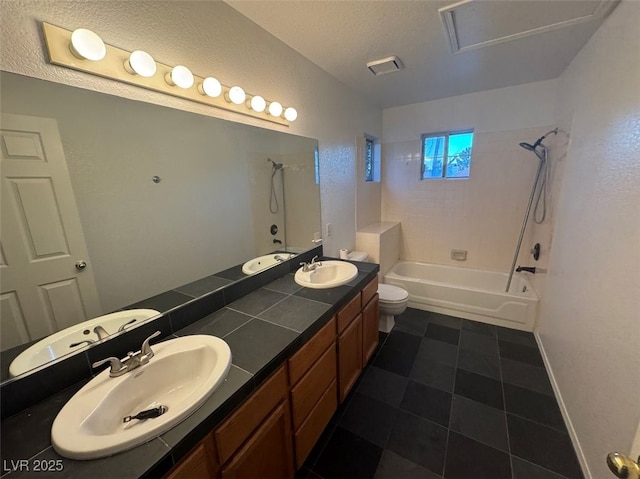 bathroom with double vanity, a textured ceiling, and a sink