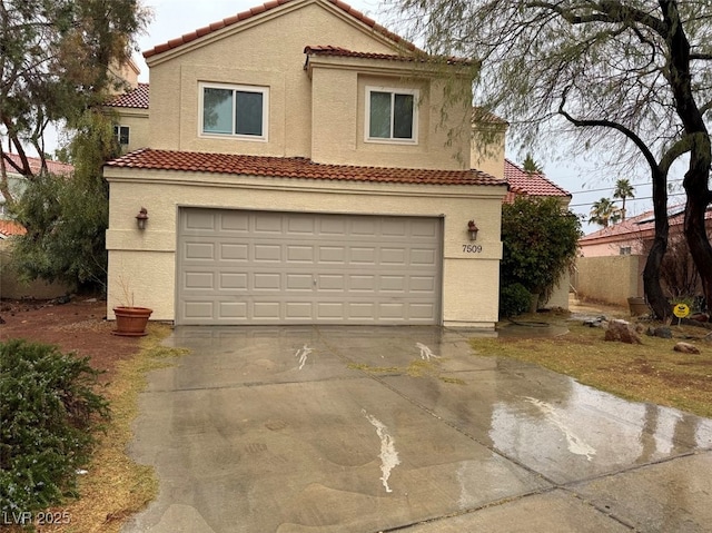 mediterranean / spanish house featuring a garage, concrete driveway, and stucco siding