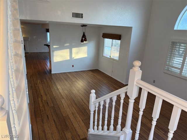 interior space with dark wood-style flooring, visible vents, and baseboards