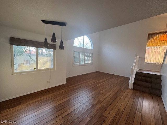 unfurnished living room featuring dark wood-type flooring and baseboards