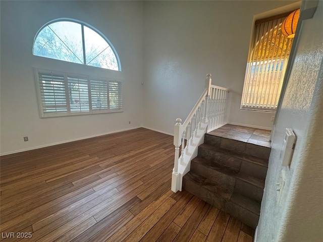 staircase featuring baseboards and wood finished floors