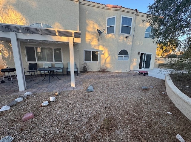 back of property featuring a patio area, a tiled roof, stucco siding, and a pergola