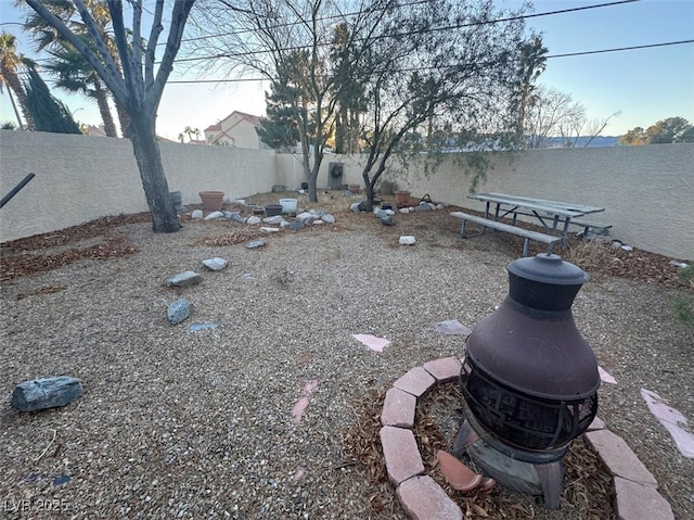 view of yard featuring an outdoor fire pit and a fenced backyard