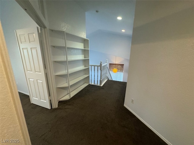 corridor with recessed lighting, baseboards, dark carpet, and an upstairs landing