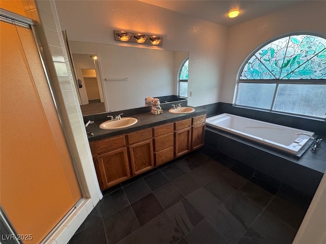 full bath featuring double vanity, a shower with shower door, a sink, and a bath