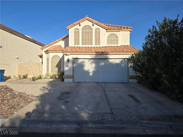 mediterranean / spanish house featuring a garage, driveway, a tiled roof, and stucco siding