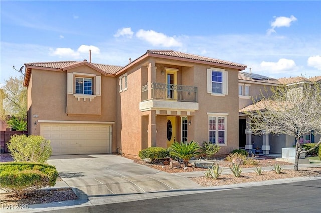 mediterranean / spanish-style house featuring a garage, a balcony, concrete driveway, and stucco siding