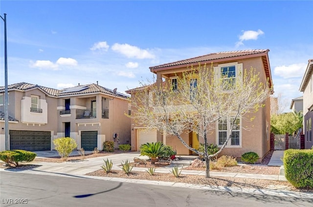 view of front of home featuring a tile roof, stucco siding, an attached garage, roof mounted solar panels, and driveway