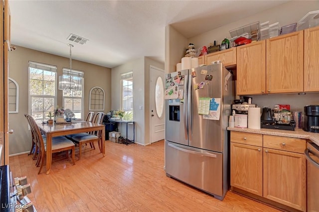 kitchen with pendant lighting, visible vents, light countertops, light wood-style flooring, and appliances with stainless steel finishes