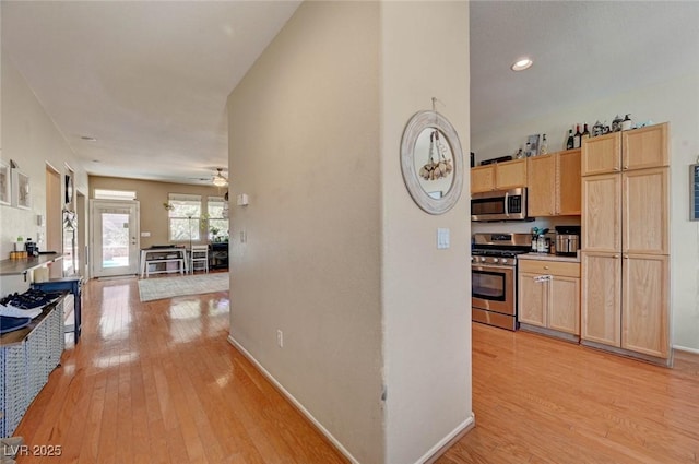 kitchen featuring baseboards, appliances with stainless steel finishes, light countertops, light wood-style floors, and light brown cabinets