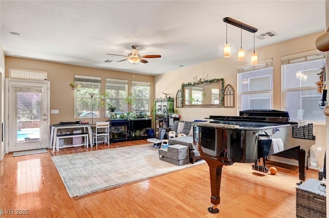 living area with a ceiling fan, visible vents, and light wood-style flooring