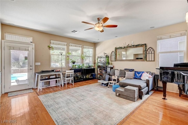 living room featuring visible vents, ceiling fan, and light wood-style flooring