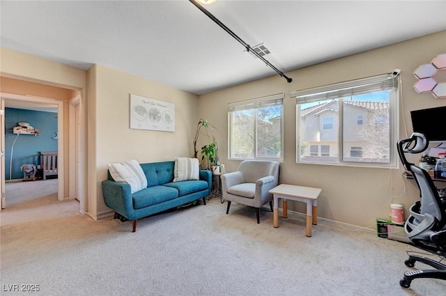 sitting room featuring baseboards, visible vents, and light colored carpet