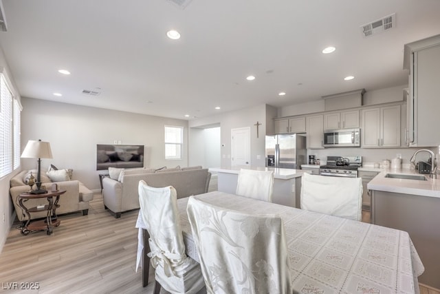 dining area with light wood-style flooring, visible vents, and recessed lighting