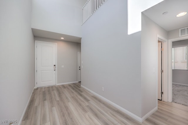 interior space with light wood-type flooring, visible vents, and baseboards