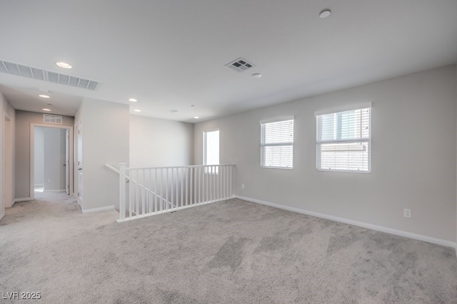 spare room with a healthy amount of sunlight, baseboards, and visible vents