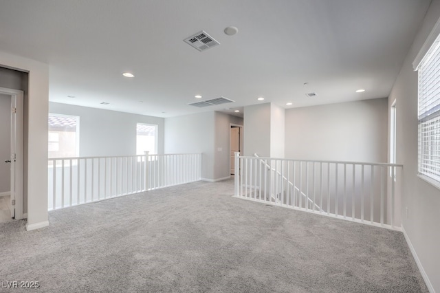 spare room featuring light colored carpet, recessed lighting, visible vents, and baseboards