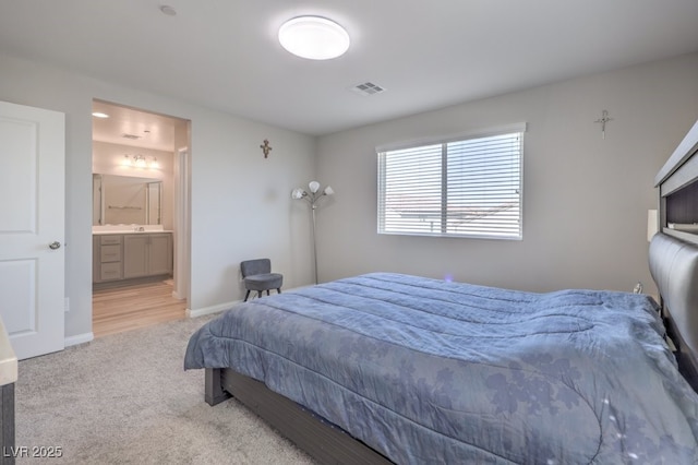 bedroom featuring light colored carpet, ensuite bath, visible vents, and baseboards