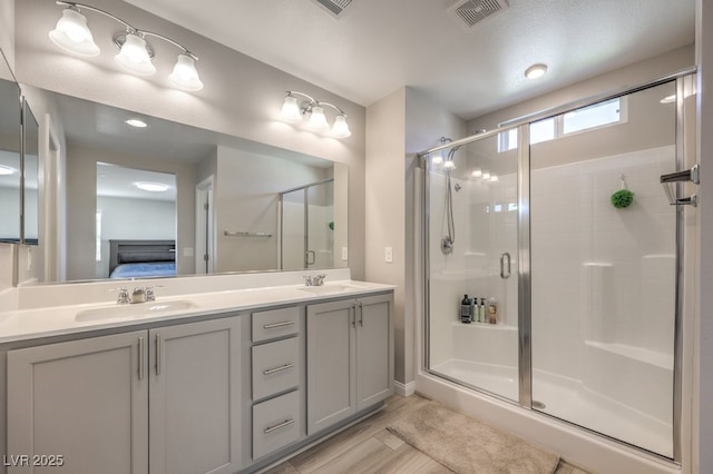 full bath featuring a stall shower, visible vents, a sink, and ensuite bathroom