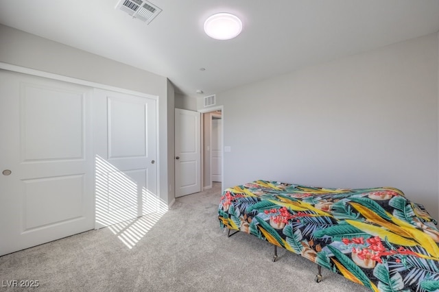 bedroom featuring a closet, visible vents, and light colored carpet