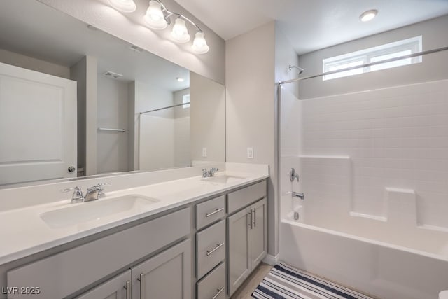 bathroom featuring tub / shower combination, a sink, visible vents, and double vanity