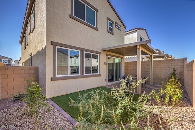 back of property featuring a fenced backyard and stucco siding