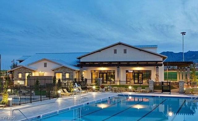 community pool featuring a patio area, fence, and a mountain view