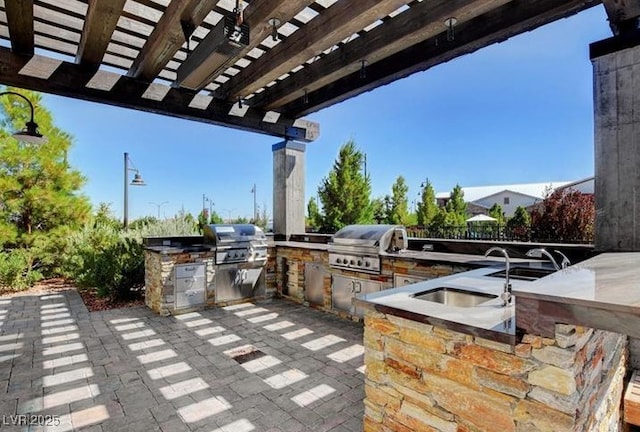 view of patio with area for grilling and a pergola