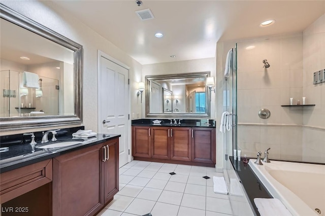 bathroom with a bath, a shower stall, two vanities, and a sink