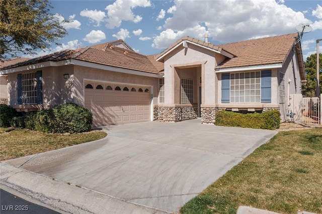 mediterranean / spanish home with stone siding, concrete driveway, an attached garage, and stucco siding