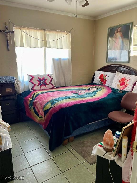 bedroom with ornamental molding, multiple windows, and light tile patterned floors