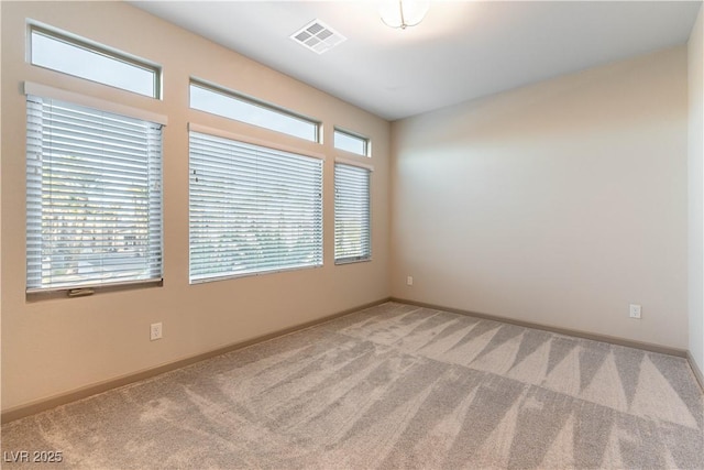 unfurnished room featuring light carpet, visible vents, and baseboards