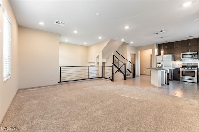 unfurnished living room with recessed lighting, light carpet, visible vents, and light tile patterned flooring