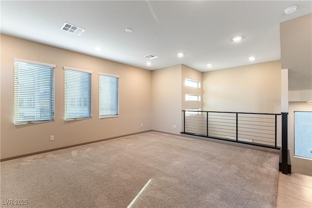 unfurnished room with recessed lighting, visible vents, light carpet, and baseboards