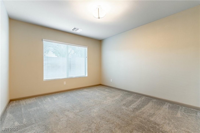 empty room featuring carpet, visible vents, and baseboards