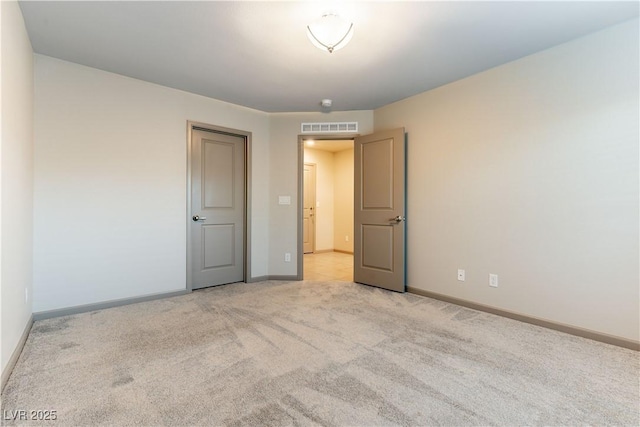 unfurnished room with baseboards, visible vents, and light colored carpet