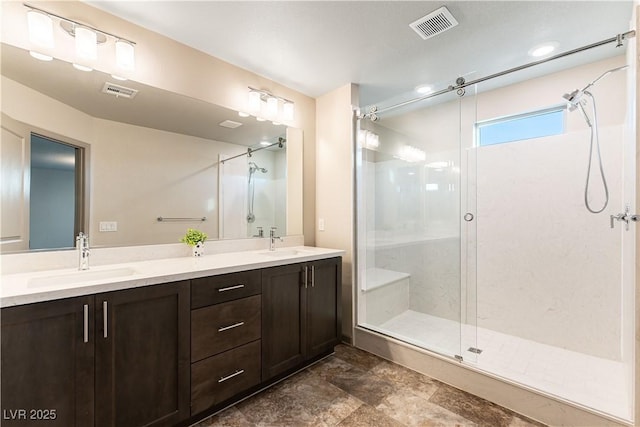 bathroom featuring double vanity, a stall shower, a sink, and visible vents