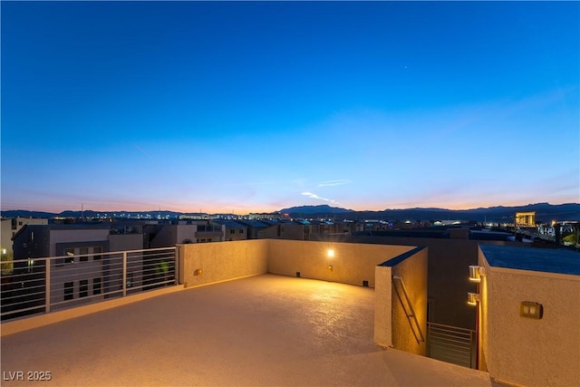 patio terrace at dusk featuring a residential view, a mountain view, and a balcony