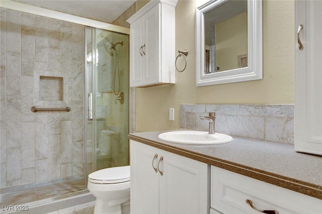 bathroom featuring a stall shower, vanity, and toilet