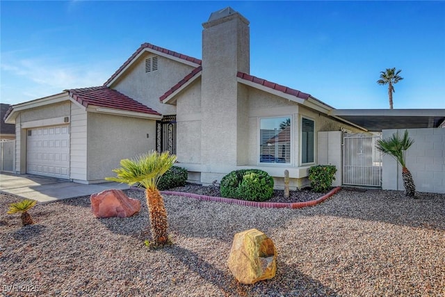 view of property exterior with a tiled roof, a chimney, an attached garage, and stucco siding