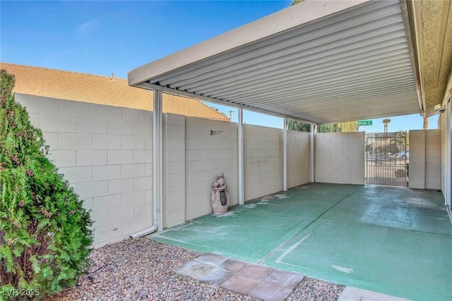 view of patio featuring a carport, a gate, and fence