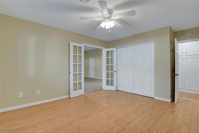 unfurnished bedroom featuring light wood-style floors, baseboards, a closet, and french doors