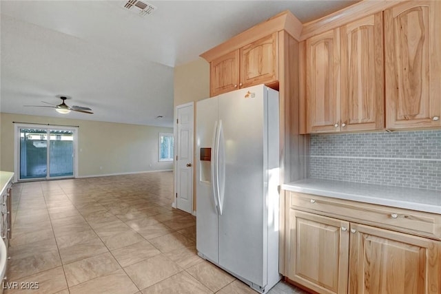 kitchen with tasteful backsplash, visible vents, light countertops, light brown cabinetry, and white fridge with ice dispenser