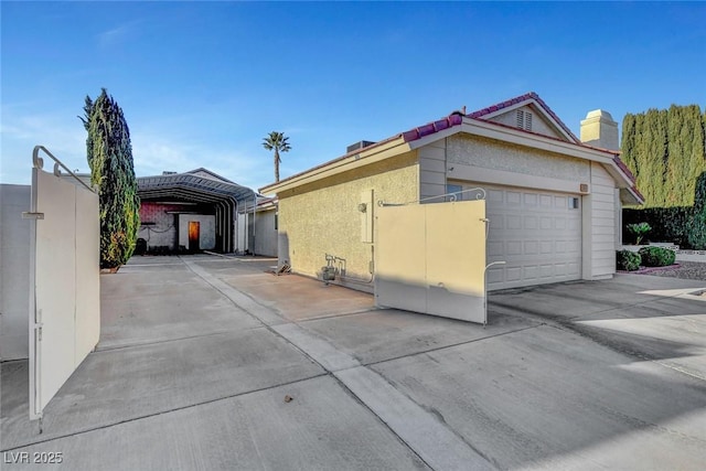 view of home's exterior featuring an attached garage, concrete driveway, and stucco siding