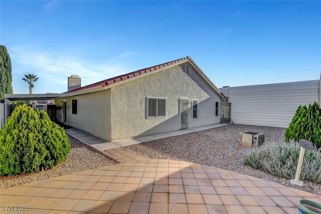 rear view of house with a patio area and stucco siding