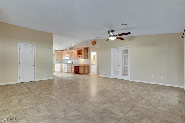 unfurnished living room featuring visible vents, baseboards, vaulted ceiling, a ceiling fan, and french doors