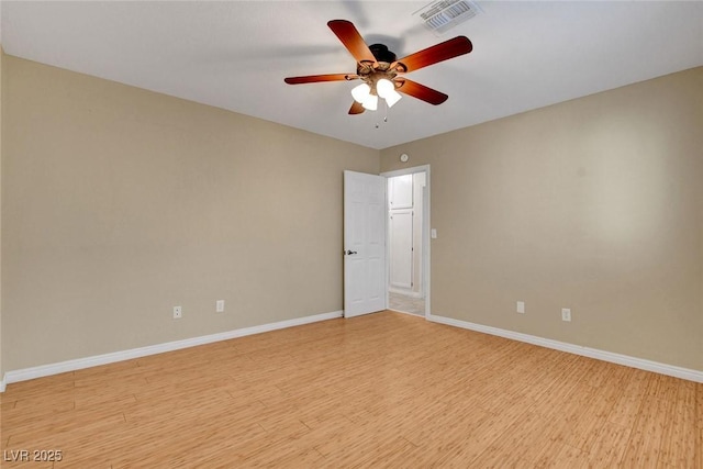 unfurnished room with baseboards, a ceiling fan, visible vents, and light wood-style floors