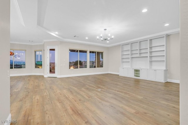 unfurnished living room with light wood finished floors, baseboards, ornamental molding, and a notable chandelier