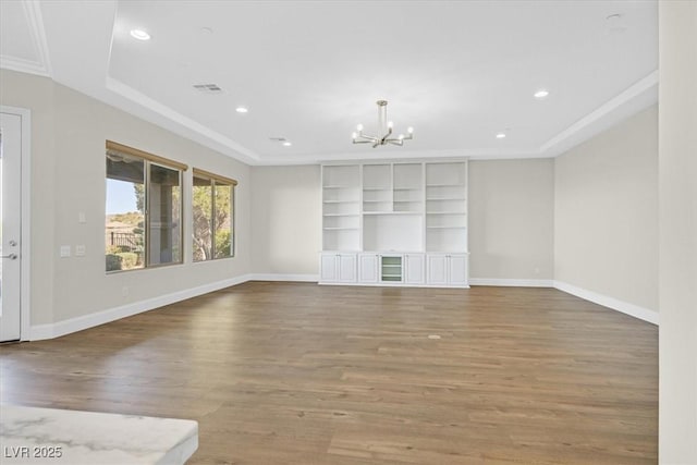 unfurnished living room with a notable chandelier, recessed lighting, wood finished floors, visible vents, and baseboards