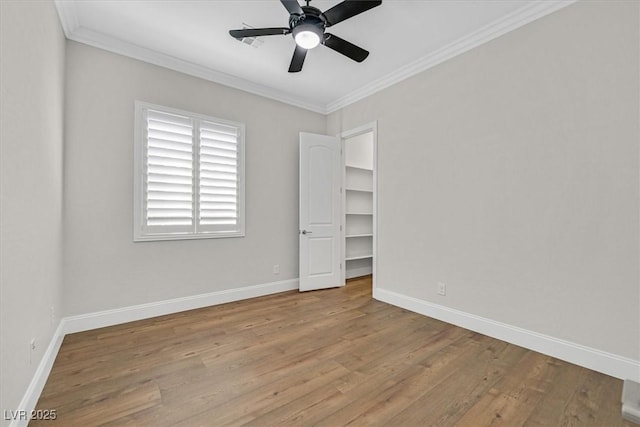 spare room with light wood-style floors, ceiling fan, baseboards, and ornamental molding